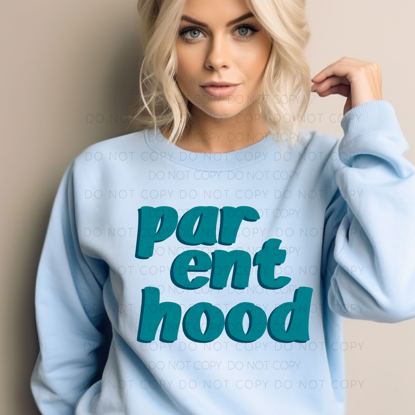 A person wearing a blue crewneck sweatshirt with the text 'parenthood' in green.