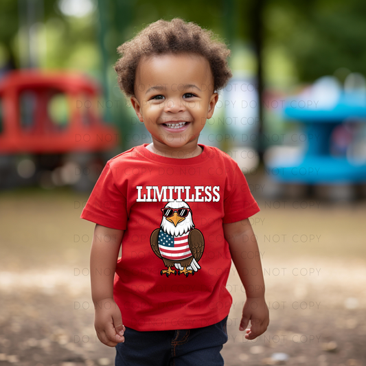 A child wearing a red unisex t-shirt with a graphic that includes an eagle and the word 'LIMITLESS'.